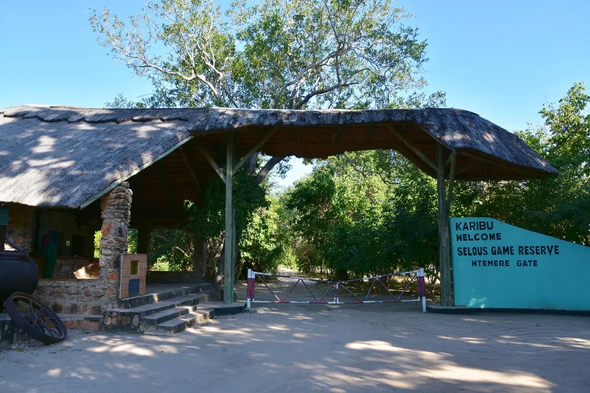 Eingangsunterstand des Parks mit Willkommensschild und sandigem Vorplatz